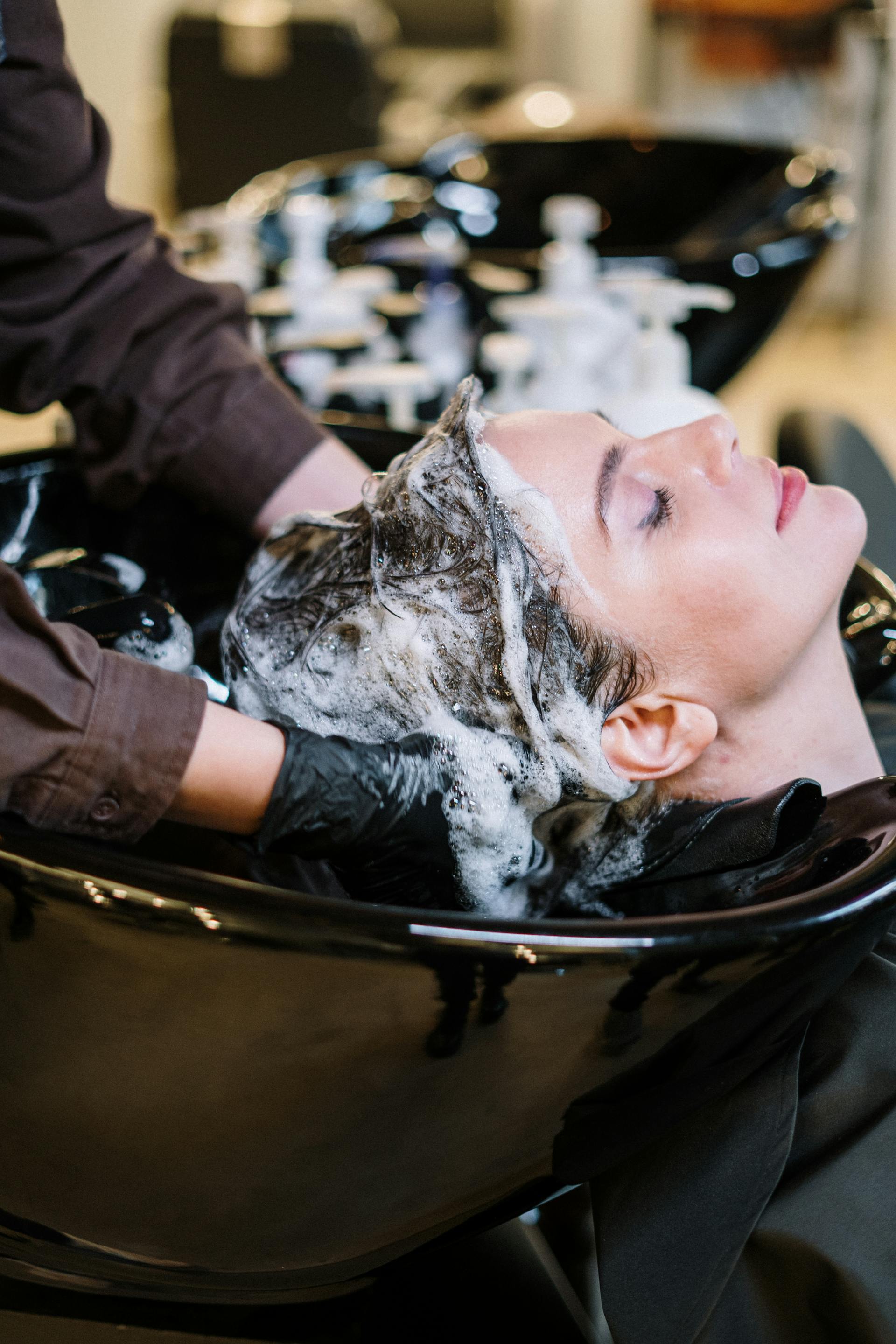 woman getting hair shampoo at salon